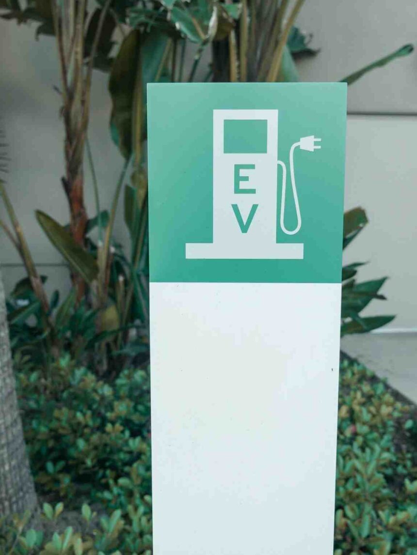 Odisha EV charging stations promotional graphic showing EV charger, electric car, temple backdrop, and state transport initiative
